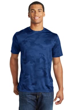 A man is wearing a navy blue Sport-Tek CamoHex Tee with a subtle camouflage pattern. The shirt features a logo.