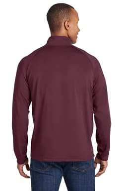 A man wearing a maroon Sport-Tek Sport-Wick Stretch 1/2-Zip Pullover, viewed from the back. The pullover has a logo.