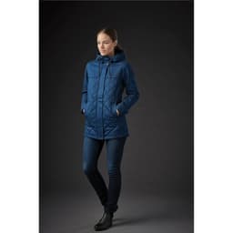 A women's quilted puffer jacket in deep blue, featuring a hood and a zippered pocket, displayed on a model.