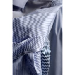 A close-up of a blue and white striped button-up shirt displaying its fabric texture and detail.