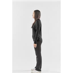 A side view of a woman wearing a black long-sleeve crew neck shirt and black pants, with a logo on the shirt.