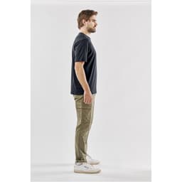 A black men's t-shirt displayed on a model standing sideways, wearing khaki cargo pants and sneakers.