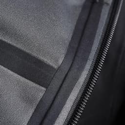 A close-up of a black softshell jacket, showcasing its fabric texture and zipper detail. It features a logo on the fabric.