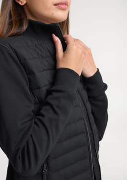 A women's tailored jacket in black, featuring a zip closure and quilted design on the body.