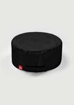 A round, black chef cap with a gathered elastic section and a small branded label.