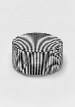 A round ottoman in a black and white checkered pattern, featuring a soft, upholstered exterior.