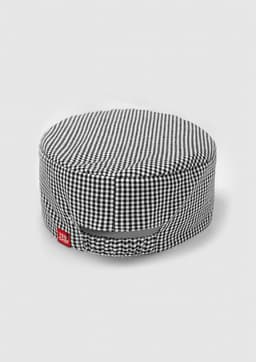 A black and white checked chef cap with a branding label on the side.