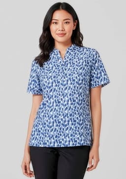 A woman wearing a short-sleeved tunic in a blue stardust print, featuring a collar and a relaxed fit.
