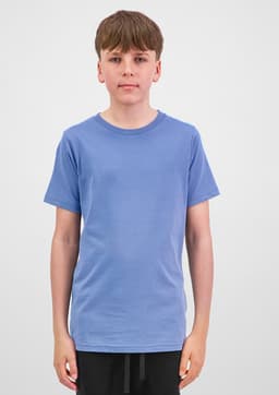 A young person wearing a short sleeve tee in light blue, standing against a plain background. The tee has a brand logo.