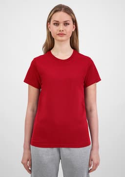 A women's short sleeve tee in red, showcased on a model with light brown hair, paired with grey bottoms.