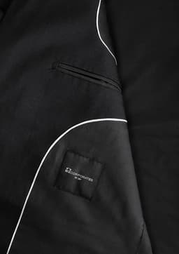 A black men's jacket featuring white piping details and a pocket with a logo.