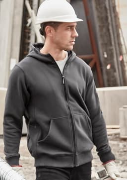 A unisex zip front multi-pocket hoodie in dark grey, featuring a hood and a logo, worn by a model at a construction site.