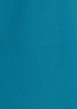 A long sleeve women's outdoor shirt in a vibrant teal colour, featuring a textured fabric and a logo.