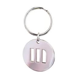 A metal key chain featuring a circular design with cut-out shapes, attached to a silver ring.
