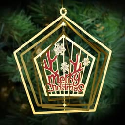 A gold 3D rotation ornament with a ‘Merry Christmas’ design and festive motifs, hanging from a tree branch.