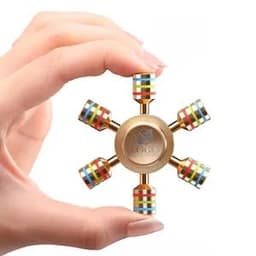 A hand holds a gold fidget spinner with hexagonal shape and colourful patterned weights on each arm.