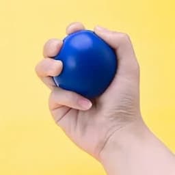 A blue round stress ball held in a hand against a yellow background.