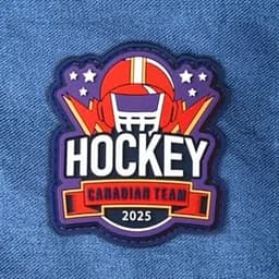 A colourful 2D PVC patch featuring a hockey theme, with a logo and vibrant graphics in red, blue, and purple.