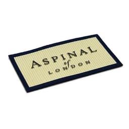A 3D silicone patch featuring a textured design in cream and navy, with an embossed logo.