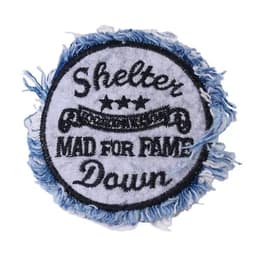 A round denim patch featuring blue frayed edges, with black embroidered text and a logo design.