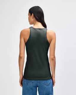 A green women's racerneck tank top with a fitted style and a logo on the back, paired with casual denim bottoms.