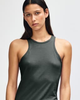 A dark green women's racerback tank top with a fitted design and straps, featuring a branding logo.