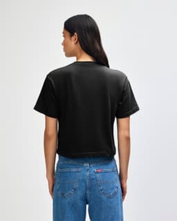 A black women's boxy T-shirt made from fine jersey fabric, featuring a simple back design and short sleeves.