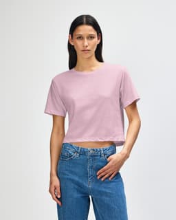 A boxy T-shirt in soft pink, featuring short sleeves and a relaxed fit, with a subtle branding on the front.