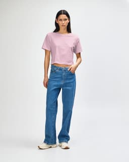 A women's fine jersey boxy T-shirt in soft pink, paired with light blue wide-leg jeans and white sneakers.