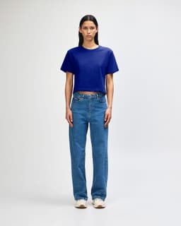 A blue boxy T-shirt paired with light blue cargo jeans and sneakers, displayed on a model. The outfit features casual styling.