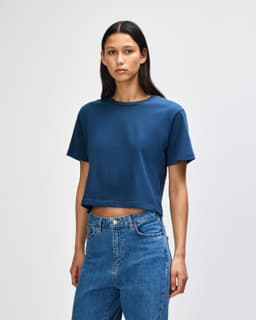 A navy boxy t-shirt with short sleeves, featuring a simple design and a logo.