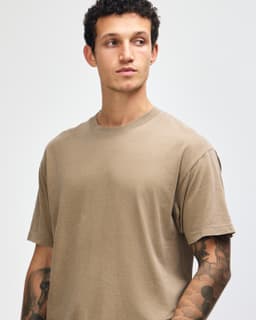 A unisex garment dyed heavyweight cotton t-shirt in a neutral brown colour, featuring a simple design and crew neck.