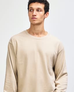 A beige heavyweight cotton unisex long sleeve t-shirt, featuring a round neckline and a plain style.