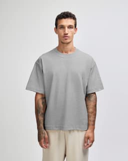 A light grey unisex boxy t-shirt made from heavyweight cotton, featuring a simple design and a logo.