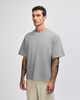A grey heavyweight cotton unisex boxy t-shirt displayed on a model, featuring short sleeves and a relaxed fit.
