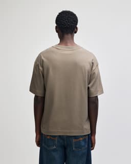 A unisex heavyweight cotton boxy T-shirt in a taupe colour, with a simple design and a small logo at the back.