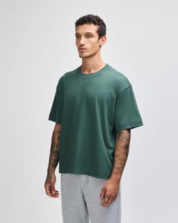 A boxy unisex T-shirt in a deep green colour, featuring short sleeves and a relaxed fit.