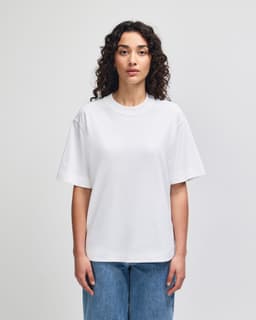 A white unisex heavyweight cotton boxy T-shirt displayed on a model, featuring a simple design and casual fit.