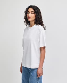 A white heavyweight cotton unisex boxy t-shirt displayed on a model against a neutral background.