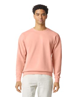 A lightweight crewneck sweatshirt in pastel pink featuring a logo. The model is wearing light-coloured pants.