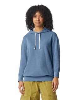 A lightweight hooded sweatshirt in blue, featuring a front pocket and a logo. The model has curly hair and is wearing cargo pants.