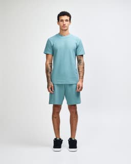 A unisex mockneck t-shirt in a soft green colour, featuring a relaxed fit and a logo.
