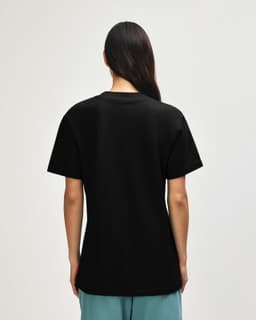 A black unisex pique mockneck t-shirt featuring a simple design and a logo on the back.