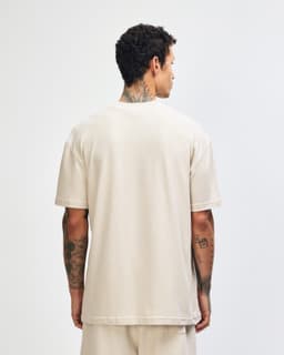 A unisex mockneck t-shirt in a soft beige colour, featuring short sleeves and a plain back. It has a logo.