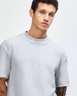 A unisex grey pique mockneck T-shirt with short sleeves, featuring a logo on the front.