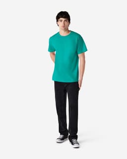 A model in a turquoise Gildan Ultra Cotton adult T-shirt, paired with black jeans and sneakers.