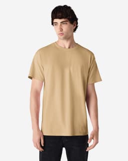 A light brown adult t-shirt displayed on a model, featuring short sleeves and a round neck. It includes a logo.
