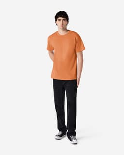 An orange Gildan Ultra Cotton adult T-shirt displayed on a male model wearing black pants and converse shoes.