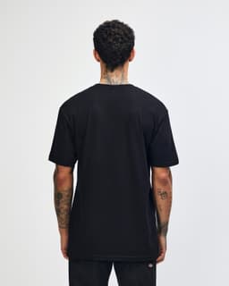A person wearing a black unisex short sleeve t-shirt, viewed from the back, with a slight curl in the hair.
