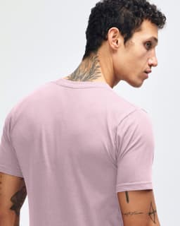 A unisex fine jersey short sleeve t-shirt in a soft mauve colour, displayed on a model paired with blue jeans.